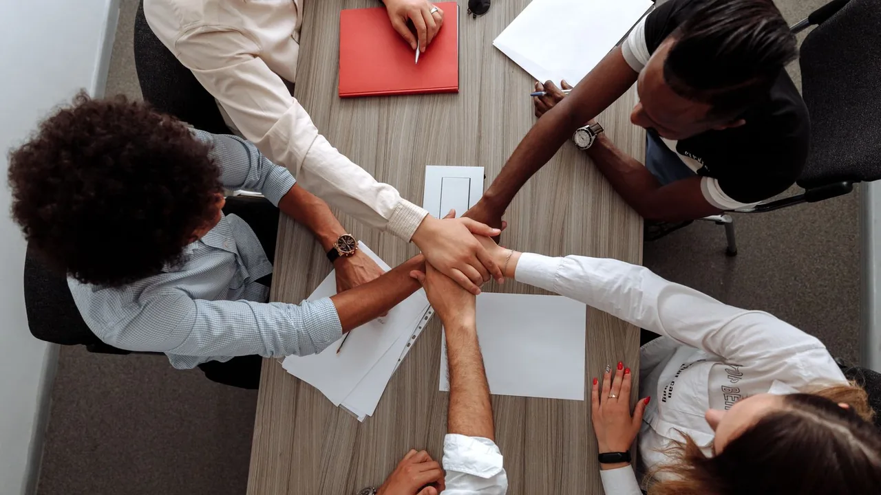 A diverse team joining hands in a community effort.