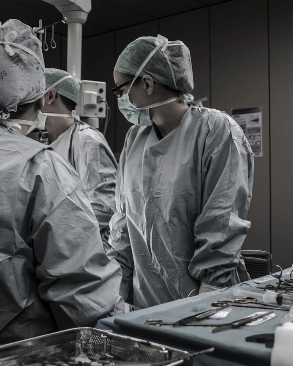 Surgical team in gowns and masks collaborating in a modern operating room.